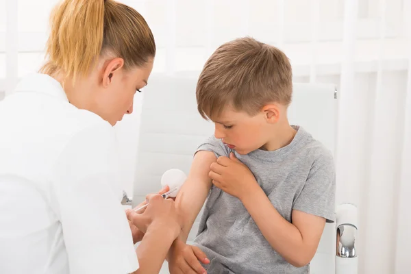Docteur donnant une injection au garçon — Photo