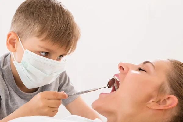 Boy Examining Teeth Of Woman Stock Image