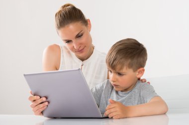 Anne ve oğlu dizüstü kullanarak