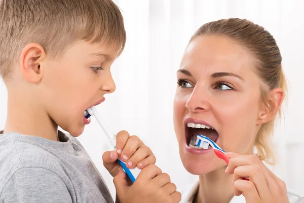 Médico e menino escovando os dentes — Fotografia de Stock