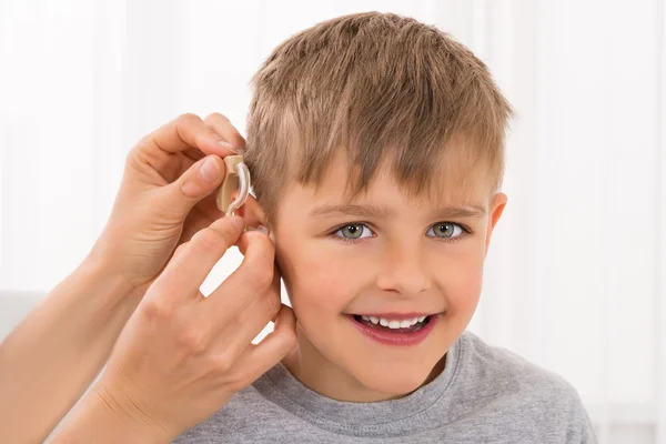 Primo piano di un ragazzo sorridente con apparecchio acustico — Foto Stock