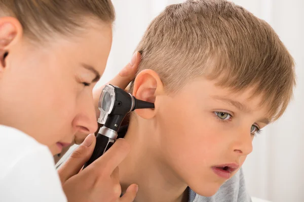 Doctor Examining Boy 's Ear — стоковое фото