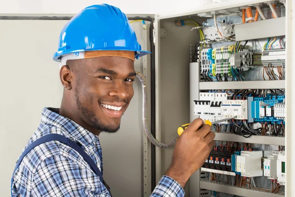 Technician Checking Fusebox con destornillador — Foto de Stock