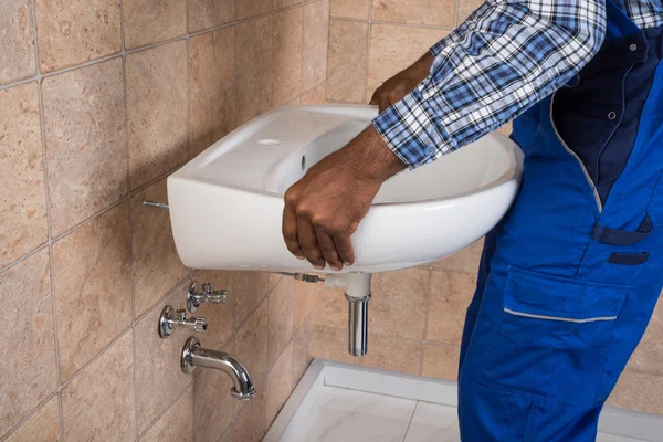 Handwerker repariert Waschbecken im Badezimmer — Stockfoto