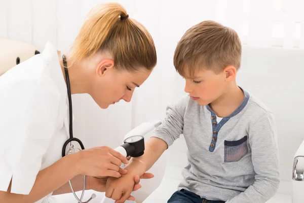 Médico examinando la piel de niño pequeño — Foto de Stock