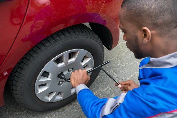 Mechaniker wechselt Reifen mit Schraubenschlüssel — Stockfoto