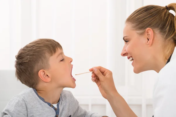 Doctor examinando la boca del niño — Foto de Stock