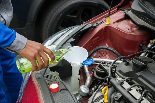 Mecánico verter aceite en el motor del coche — Foto de Stock