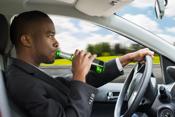 Homme d'affaires buvant de la bière tout en conduisant une voiture — Photo