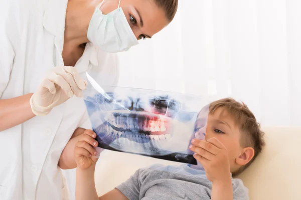 Dentista mostrando los dientes de rayos X a paciente infantil — Foto de Stock