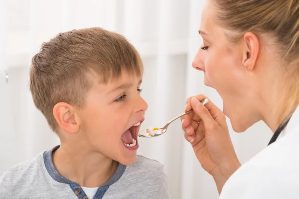 Läkare att ge medicin till pojke — Stockfoto