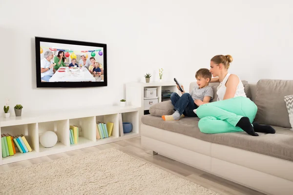 Mãe e filho assistindo televisão em casa — Fotografia de Stock