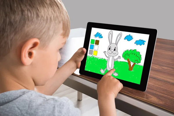 Chlapec se dotknete obrazovky na digitálním tabletu — Stock fotografie