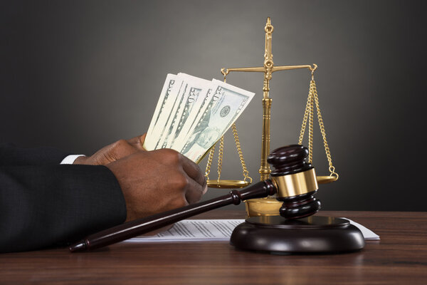 Судья считает банкноты на долларах
