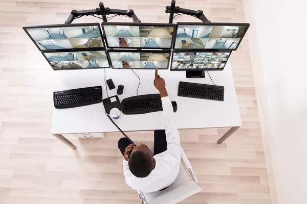 Male Operator Pointing At CCTV Footage On Computer — Stock Photo, Image