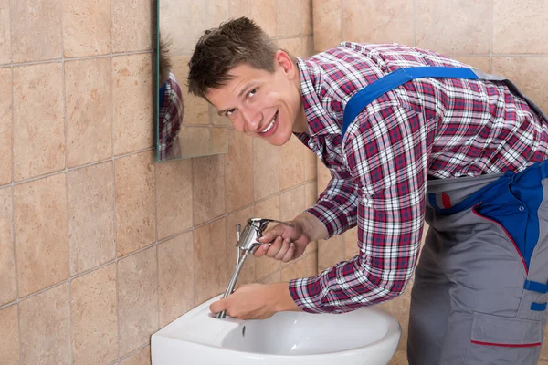 Loodgieter tot vaststelling van de kraan van de wastafel — Stockfoto