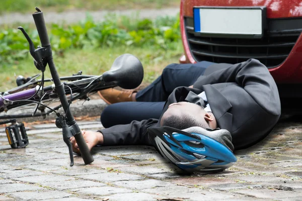 Велосипедист лежит на улице после аварии — стоковое фото