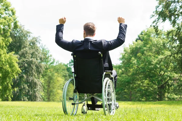 Young Disabled Man On Wheelchair With Arm Raised — Stock Photo, Image