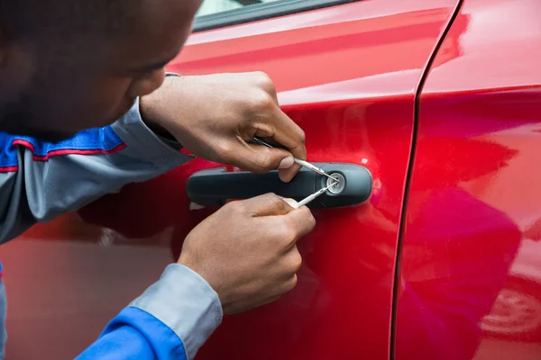 Mechaniker hält Schlüsseldienst am Öffnen der Autotür — Stockfoto