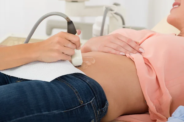 Médecin échographie en mouvement sonde sur l'estomac de la femme enceinte — Photo