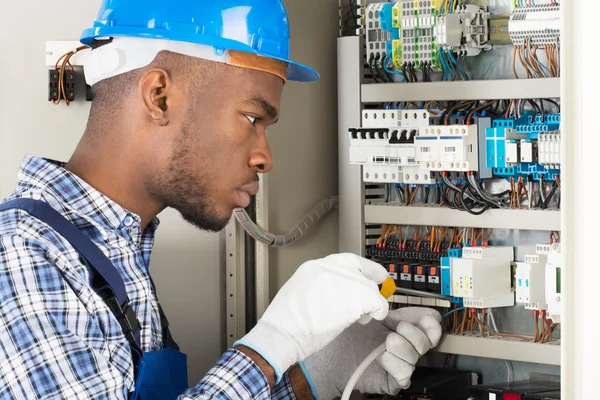 Técnico que repara Fusebox com chave de fenda — Fotografia de Stock