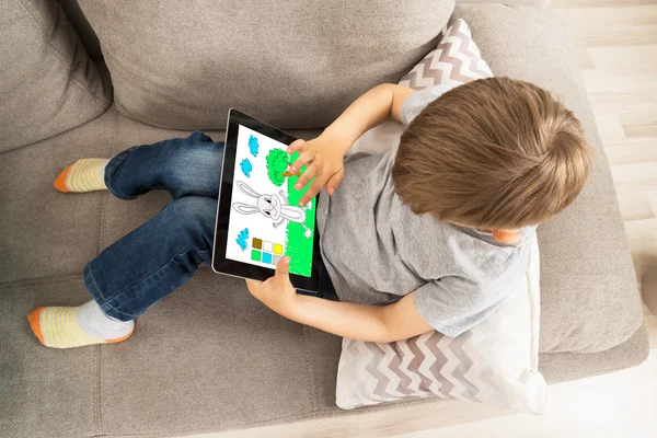 Мальчик наслаждается игрой на цифровом планшете — стоковое фото