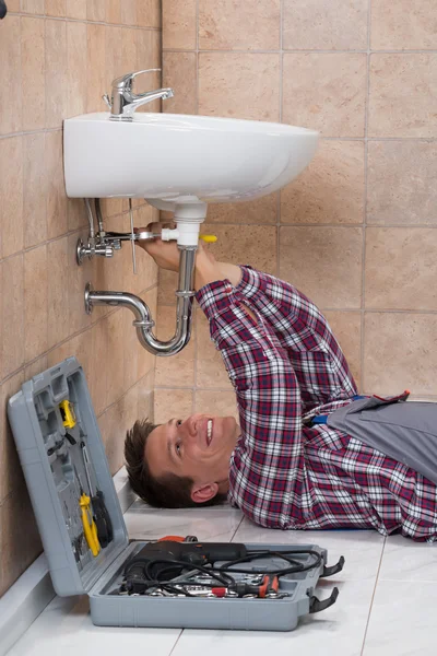 Plumber Lying On Floor Fixing Sink — Stock Photo, Image