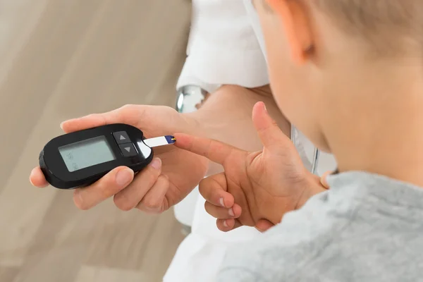 医者の子供の患者の血糖値を測定 — ストック写真