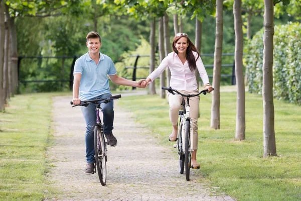 Det lyckliga paret cykling i Park — Stockfoto