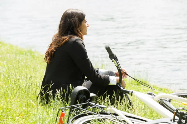 Бізнес-леді сидить біля озера — стокове фото