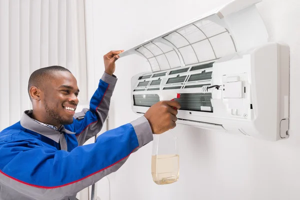 Techniker reinigt Klimaanlage — Stockfoto