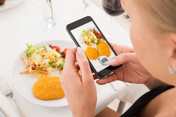 Mujer tomando fotos de comida con teléfono móvil —  Fotos de Stock