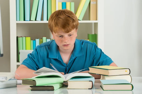 Niño estudiando en la biblioteca — Foto de Stock