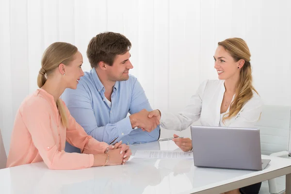 Konsult skakar hand med par — Stockfoto