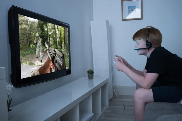 Niño jugando juego de acción en la televisión — Foto de Stock