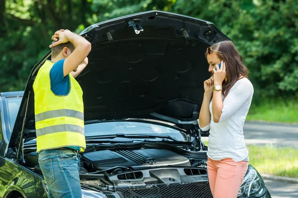 Frau telefoniert mit stehendem kaputten Auto — Stockfoto