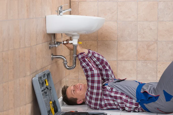 Plumber Lying On Floor Fixing Sink — Stock Photo, Image