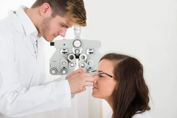 Manliga optiker bär glasögon till kvinnan — Stockfoto