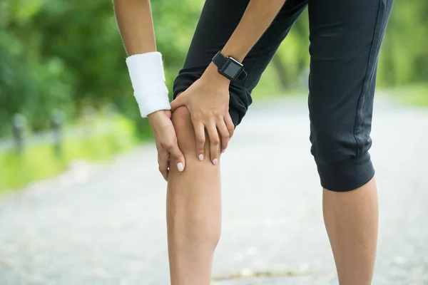 Žena jogger having bolest v ji koleno — Stock fotografie