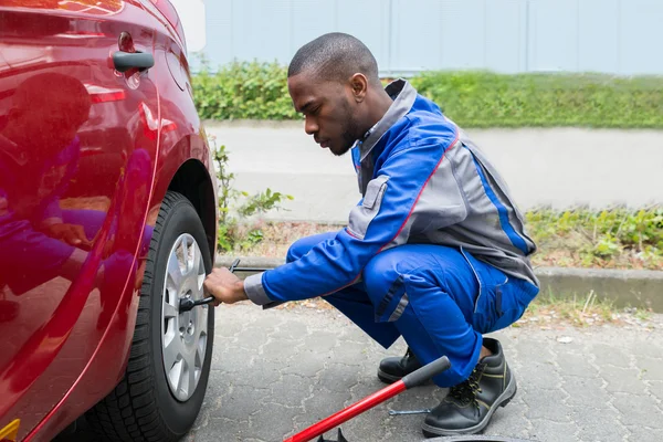 Mechaniker wechselt Reifen mit Schraubenschlüssel — Stockfoto