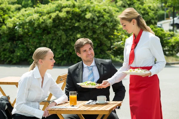 Cameriera che serve cibo agli uomini d'affari — Foto Stock