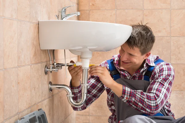 Glimlachend loodgieter herstellen wastafel — Stockfoto