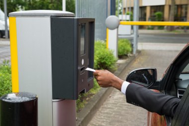 Makine otopark kullanarak arabada oturan kişi