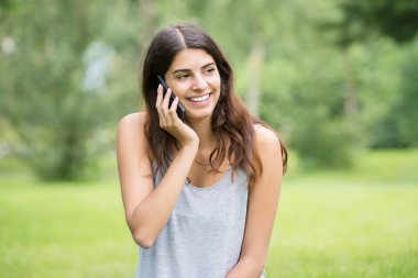 Mobil telefonda konuşurken gülümseyen kadın