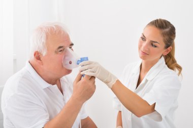 Patient Inhaling Through Oxygen Mask clipart