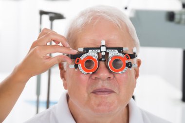 Bir Optometrist hasta vizyonu ile deneme çerçeve denetimi