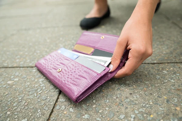 Kobieta, zbierając upadłych portfel — Zdjęcie stockowe