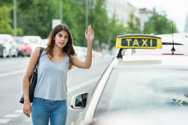 Женщина вызывает такси на улице — стоковое фото