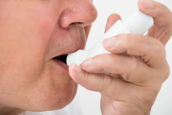 Hombre usando inhalador de asma — Foto de Stock