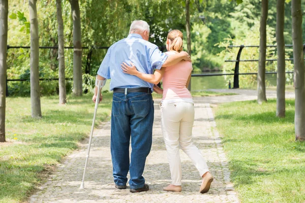 Donna con suo padre disabile in piedi nel parco — Foto Stock